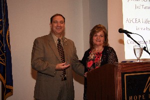In July, Linda Skinner, chapter membership officer, presents a commemorative coin to Norman Nelson, chapter executive vice president, in appreciation for his ongoing membership recruitment and retention efforts. 